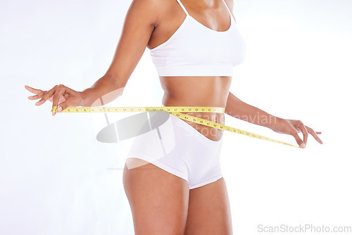 Image of Health, stomach and diet, woman with measuring tape on waist, exercise and weightloss isolated on white background. Fitness, healthcare and tummy tuck motivation or liposuction progress in studio.