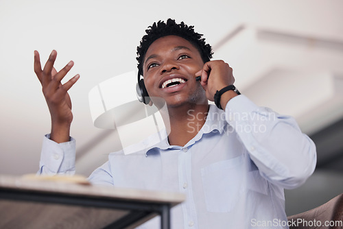 Image of Call center, black man and communication in low angle for customer service, telemarketing and office consultant. Sales agent talking on headset for tech support, questions and telecom lead generation