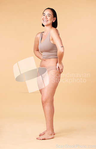 Image of Portrait, skincare and beauty of Asian woman in lingerie in studio isolated on a brown background. Underwear, makeup and cosmetics of happy young model with self love, body care and skin wellness.