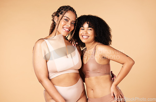 Image of Skincare, beauty and black women friends in underwear in studio isolated on a brown background. Empowerment portrait, lingerie and body positive happy girls with makeup, cosmetics and healthy skin.