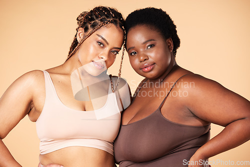 Image of Portrait, beauty and plus size with black woman friends in studio on a beige background for body positivity. Makeup, diversity or wellness with a model female and friend posing to promote inclusion
