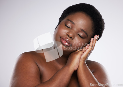 Image of Relax, skincare beauty or black woman with makeup or cosmetics isolated on a gray studio background. Hands, face or African plus size model resting with spa facial products for self love or care