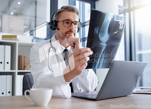 Image of Doctor, x ray and man with headset and laptop in hospital for healthcare or online consultation. Thinking, radiology telehealth and mature medical physician looking at mammogram picture or bone xray.