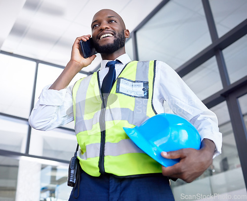 Image of Black man, construction worker or phone call in building planning, networking or industrial property design in low angle. Smile, happy or engineering architect with mobile technology, helmet or ideas
