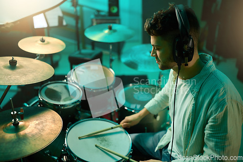 Image of Music, drums and instrument with a man musician in a studio for a recording, performance or practice. Art, band and sound with a young male drummer expressing musical or artistic talent in a studio