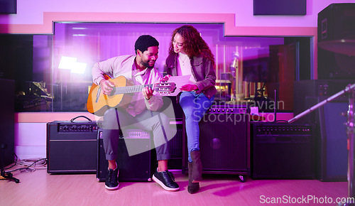 Image of Black man, woman and songwriting with guitar, studio and night with paper for creative lyrics, notes and ideas. Music team, writing and singing together for professional production with teamwork