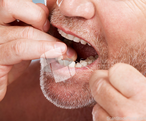 Image of Dental, hands and mouth of man with floss in studio isolated on background for health. Oral hygiene, wellness and face of senior male model with thread or string for flossing, cleaning or teeth care.