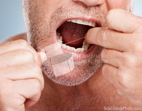 Image of Hands, dental and mouth of man with floss in studio isolated on a gray background for health. Oral hygiene, wellness and senior male model with thread or string for flossing, cleaning or teeth care.