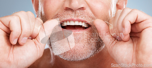 Image of Closeup, floss and man with dental health, cleaning teeth and fresh breath against grey studio background. Male, gentleman and string for oral hygiene, wellness and morning routine for mouth grooming