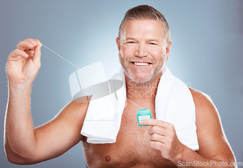 Image of Dental, floss and portrait of man with product in studio isolated on a gray background. Oral hygiene, health and mature male model with container with thread for flossing, cleaning and teeth care.