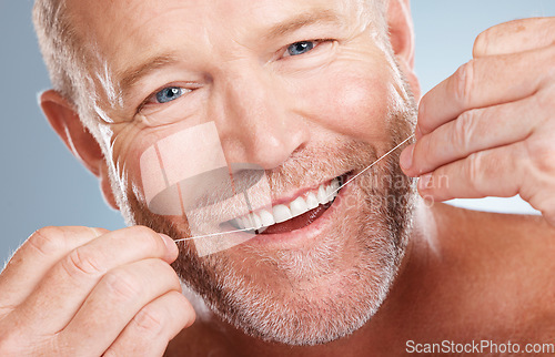 Image of Face portrait, dental and with man with floss in studio isolated on a gray background for health. Oral hygiene, wellness and happy senior male model with thread for flossing, cleaning or teeth care.