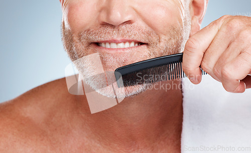 Image of Skincare, grooming and man brush beard for wellness, healthy skin and hygiene on blue background. Barber aesthetic, cleaning and face zoom of male with comb for facial treatment, beauty and hair care