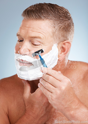 Image of Face, shaving cream and man with razor in studio isolated on a gray background for hair removal. Cleaning, skincare and senior male model with facial foam to shave for aesthetics, health or wellness.