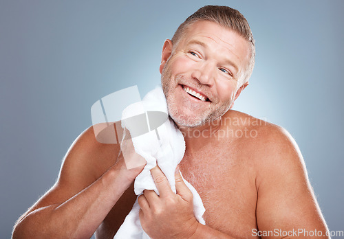 Image of Happy, old man and skincare in studio with towel for face, cleaning or grooming on grey background. Facial, mature and male model relax for luxury, skin or beauty, wrinkles or treatment and isolated