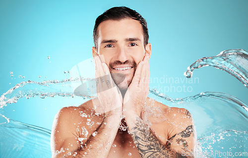Image of Water splash, skincare and portrait of man cleaning face, morning treatment isolated on blue background. Facial hygiene, male model and grooming for health, wellness and clean skin care in studio.