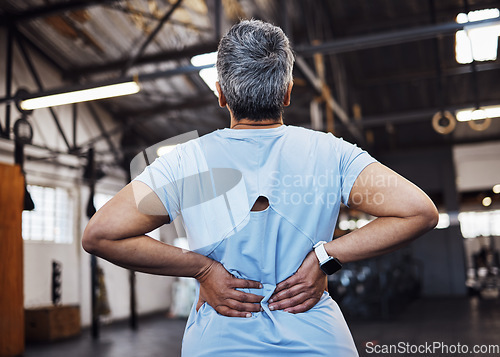 Image of Back pain, woman and in gym for exercise, fitness and muscle strain with tension, wellness and workout. Female, lady or athlete with injury, medical risk or healthcare with training or sports burnout