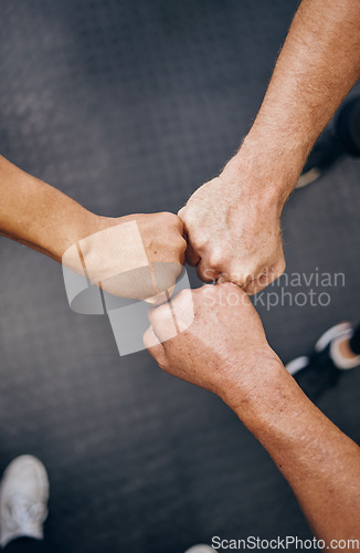 Image of Hands, motivation and collaboration with people in the gym from above for health, fitness or solidarity. Teamwork, training and partnership with an athelte group doing a fist bump together for unity