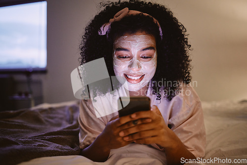 Image of Black woman, afro or skincare mask and phone in house bedroom, home or hotel on social media app or web. Smile, happy or facial product on relax person on mobile technology for face grooming research