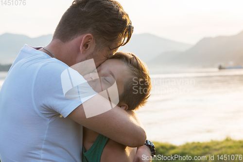 Image of Father and his son playing and hugging outdoors