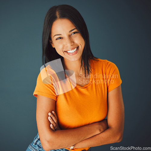 Image of Portrait, fashion and arms crossed with a woman in studio on a gray background for confidence or positive attitude. Happy, smile and confident with an attractive young female posing indoor for style