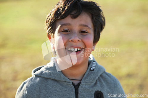 Image of Happy, smile and portrait of a child in nature having fun while enjoying outdoor fresh air. Happiness, excited and face of a boy kid standing in a park while on a summer vacation, holiday or trip.