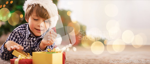 Image of Boy, child or opening christmas present on living room floor, house or home with mockup, bokeh or mock up space. Smile, happy or festive kid with gift box in celebration, holiday or tradition giving