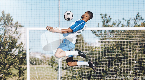 Image of Sports, soccer and man jump with ball playing game, training and exercise on outdoor field. Fitness, workout and male football player for defence, goalkeeper and in action for goals in competition