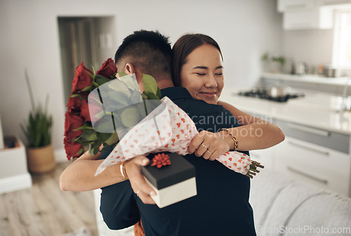 Image of Couple hug, present and roses surprise of an Asian woman with gift on valentines day. Living room, rose bouquet and lounge of people with love, care and happiness together with a smile from present