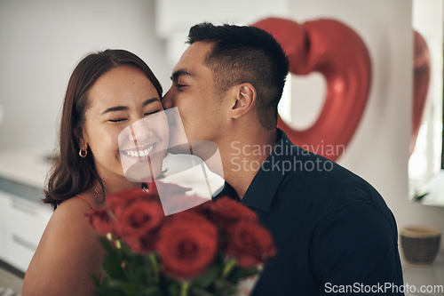 Image of Love, rose and valentines day with a couple kissing in their home, in celebration of romance. Dating, flower boquet or surprise with a man and woman in a house to kiss while bonding in intimacy