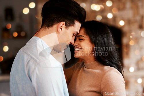 Image of Love, romance and couple hugging while on a date for valentines day or anniversary celebration. Happy, intimate and young interracial man and woman embracing while at romantic evening dinner together