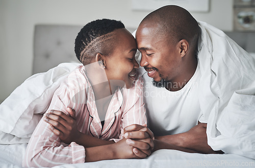 Image of Love, relax and black couple lying in bed in a hotel for valentines day, anniversary or romance. Intimacy, happy and young African man and woman relaxing in bedroom while on romantic vacation or trip