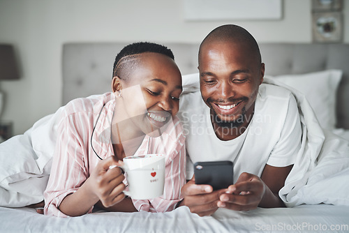 Image of Black couple in bed with phone, coffee and happiness with morning routine, social media or streaming online. Wifi, communication and technology with happy man and woman, relax at home together