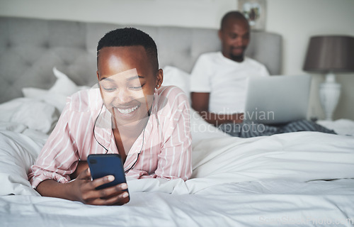 Image of Black woman with smartphone, relax in bed with technology and online communication, website and wifi. Man with laptop, couple happy at home with tech, social media and internet connectivity with app