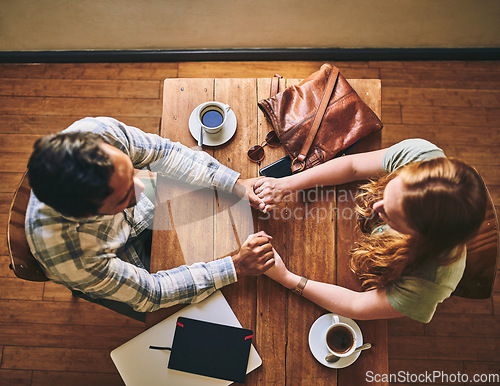 Image of Top view, couple and holding hands in cafe, celebration and relax together, Valentines day and romance. Romantic, man and woman with love, coffee shop and talking for relationship, loving and bonding