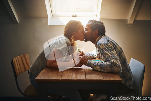 Image of Kiss, couple love and holding hands at cafe on table, passion or bonding together. Valentines day, romance diversity and affection of man and woman on date, kissing and enjoying time in restaurant.