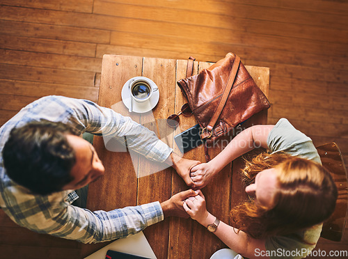 Image of Top view, couple and cafe with holding hands, love and conversation for romance at table. Man, woman and valentines date in coffee shop for support, bonding and talking with happiness, care and trust