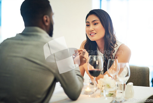 Image of Couple, holding hands and wine in restaurant with talking, love and romance for valentines day date in night. Black man, asian woman and conversation for bonding, luxury fine dining and celebration