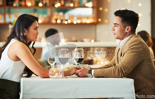 Image of Couple holding hands, date in restaurant and celebrate Valentines day holiday with love, romance and fine dining. Commitment, interracial relationship and man with woman together, trust and support