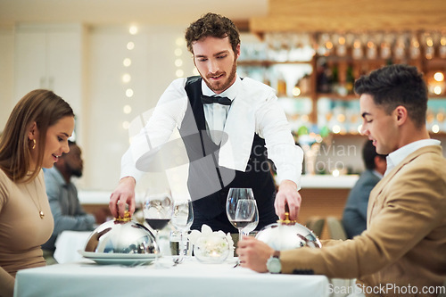 Image of Couple, restaurant server and fine dining with food for valentines day date, love and romance in night. Man, woman and waiter with service, party and hospitality for dinner, bonding and celebration