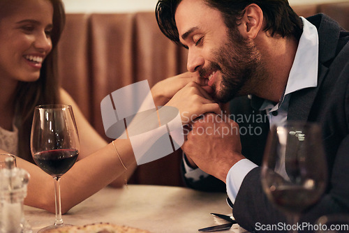 Image of Hand, kiss and date with a couple in a restaurant on a night out together for love, fine dining or luxury. Anniversary, romance and affection with a man kissing his wife while dating in celebration