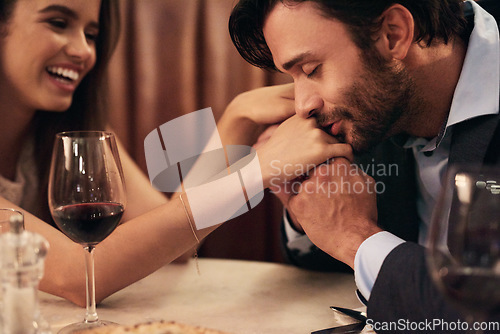 Image of Hand, kissing and love with a couple in a restaurant on a date night out together for fine dining or luxury. Love, romance and affection with a man and wife sharing a kiss while dating in celebration