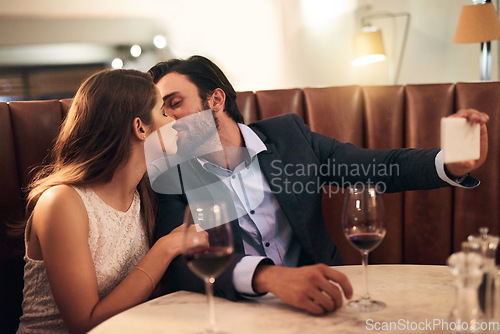 Image of Kiss, selfie and romantic couple fine dining at a luxury restaurant with love, care and happiness together. Lovers, people and man taking a picture with his woman on valentines day for social media