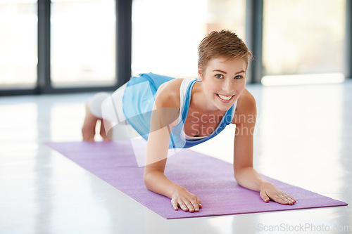 Image of Woman, portrait smile and plank on yoga mat for healthy fitness, strong core or zen workout indoors. Happy female yogi stretching for abdominal muscle training, balance or wellness exercise at a gym