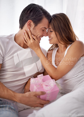 Image of Man giving woman gift box, love and smile with partner, relationship and celebration on Valentines day. Couple with present, forehead touch and luxury, commitment and gratitude, celebrate holiday