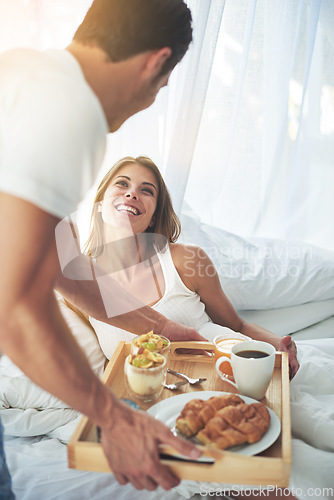 Image of Love, couple and breakfast in bed, smile and Valentines day celebration for quality time, loving and bonding. Romance, man and woman with food in bedroom, happiness and enjoy marriage or relationship