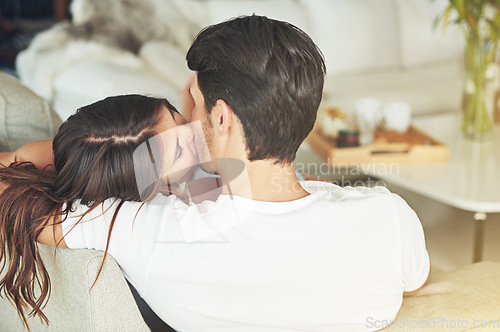 Image of Love, kiss and couple relax on living room sofa for home Valentines Day, bonding and quality time together. Marriage, vacation and back of romantic people in holiday house in Rio de Janeiro Brazil