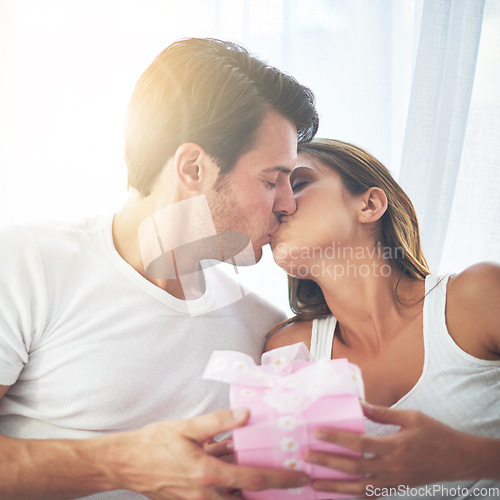 Image of Couple kiss with gift, love and care, thank you for present on Valentines day, date with commitment at home. Luxury, gratitude and romance in partnership, man and woman celebrate with intimacy