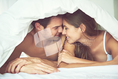 Image of Love, couple and happy in bed, waking up and bonding in a bedroom together, flirting and romantic. Romance, man and woman relax, intimate and resting at hotel for valentines day, anniversary or bond