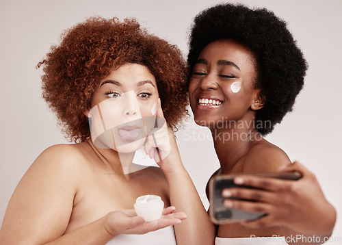Image of Skincare, comic and beauty with friends and selfie for product, facial and spa luxury. Meme, phone and social media with women and funny face with cream for health, makeup and wellness in studio