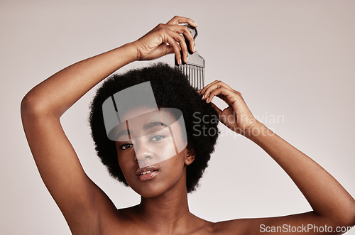 Image of Afro comb, black woman and portrait of a model with hair care, salon and cosmetics. Hairdresser comb, African hairstyle and beauty of a young person doing a treatment for self care in a studio